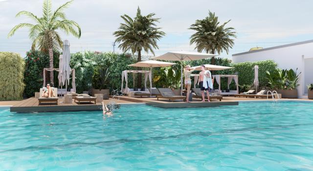 Piscina con palme, lettini e persone che si rilassano.